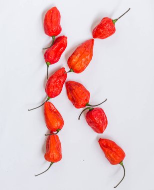 K harfi alfabesi ile hayalet biber Bhoot jolokia beyaz arka plan üzerinde yapılan