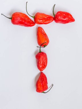 T harfinin alfabesi ile hayalet biber Bhoot jolokia beyaz arka plan üzerinde yapılan