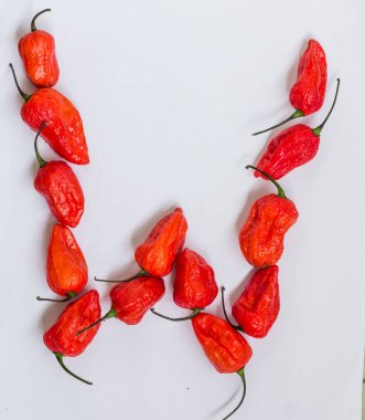 Mektup W alfabesi ile hayalet biber Bhoot jolokia beyaz arka plan üzerinde yapılan