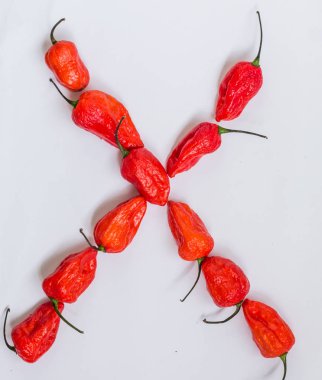 Mektup X alfabesi ile hayalet biber Bhoot jolokia beyaz arka plan üzerinde yapılan