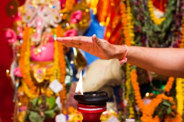 bir el alarak ısı alev yanan kil lamba bir kil üzerine nimet olarak ayakta ya da Idol durgapuja Hindistan diwali ibadet