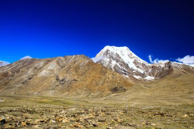 Derin mavi gökyüzü ve buz beyaz bulutlar ile Himalaya Dağları doruklarına gün süre içinde şapkalı.