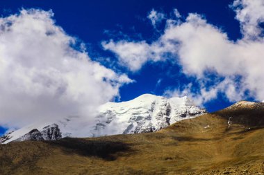 Derin mavi gökyüzü ve buz beyaz bulutlar ile Himalaya Dağları doruklarına gün süre içinde şapkalı.