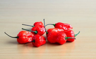 Kırmızı Bhoot Jolokia baharatlı hayalet demet izole ahşap arka plan metin için yer ile biber