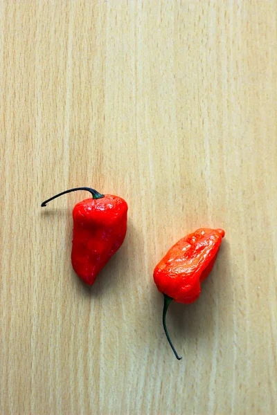 Dvě Červené Bhoot Jolokia Pikantní Ghost Pepř Izolované Dřevěné Pozadí — Stock fotografie
