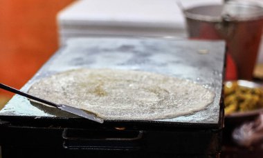 Dosa yağda kızartılır sonra pişirme kaşık ile bir Tawa Pan üzerinde kağıt düz dosa kenarı serbest bırakma.