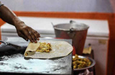 Bir kızartma tavasında masala dosa yapmak için patates masala ekledikten sonra dosa katlanır