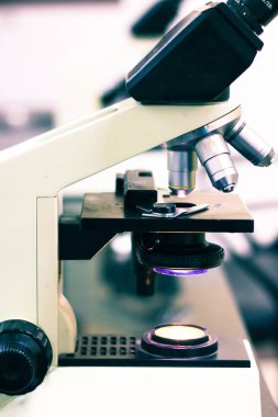 üzerinde ışık içeren düğme ve vidalar içeren hafif bir mikroskop