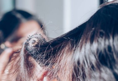 Bayan onun saç saç fırçası, ayna ile tarama.