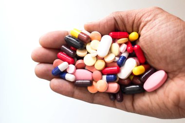 Tıp hapları yığını kapsül içinde beyaz arka planda bir palmiye tablet