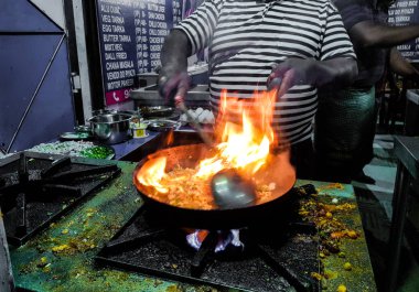 alevler içinde tadka fry bir tavada bir yol yan gıda köşesinde bir ocakta yemek bir şef