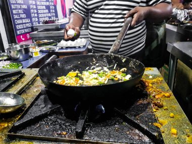 alevler içinde tadka fry bir tavada bir yol yan gıda köşesinde bir ocakta yemek bir şef
