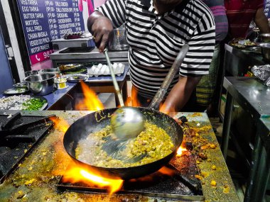 alevler içinde tadka fry bir tavada bir yol yan gıda köşesinde bir ocakta yemek bir şef