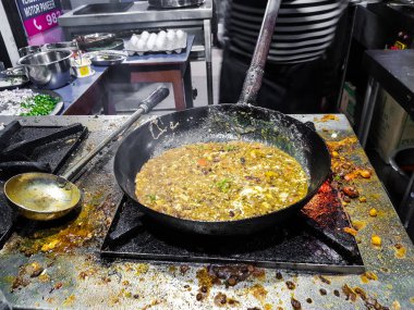 alevler içinde tadka fry bir tavada bir yol yan gıda köşesinde bir ocakta yemek bir şef