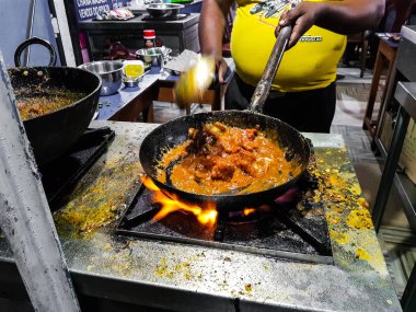alevler içinde tadka fry bir tavada bir yol yan gıda köşesinde bir ocakta yemek bir şef