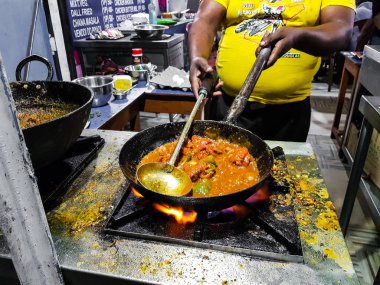 alevler içinde tadka fry bir tavada bir yol yan gıda köşesinde bir ocakta yemek bir şef