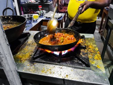alevler içinde tadka fry bir tavada bir yol yan gıda köşesinde bir ocakta yemek bir şef
