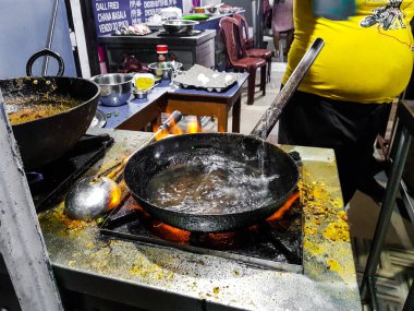 alevler içinde tadka fry bir tavada bir yol yan gıda köşesinde bir ocakta yemek bir şef