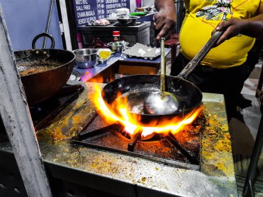 alevler içinde tadka fry bir tavada bir yol yan gıda köşesinde bir ocakta yemek bir şef