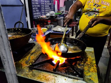 alevler içinde tadka fry bir tavada bir yol yan gıda köşesinde bir ocakta yemek bir şef