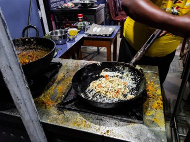 alevler içinde tadka fry bir tavada bir yol yan gıda köşesinde bir ocakta yemek bir şef