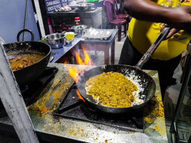 alevler içinde tadka fry bir tavada bir yol yan gıda köşesinde bir ocakta yemek bir şef