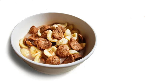 Vanilla and chocolate cornflakes dipped in chocolate milk in a white bowl in light background — Stock Photo, Image