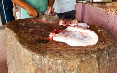 Yağlı kırmızı et el bakır bıçak ile bir kasap tarafından ahşap bir platformda elle kesilmiş