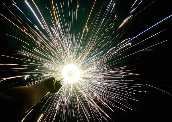 Mano charki, un fuoco d'artificio a mano che emette scintille circolari in sfondo nero — Foto Stock