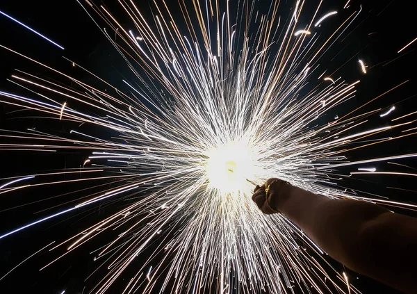 Mano charki, un fuoco d'artificio a mano che emette scintille circolari in sfondo nero — Foto Stock