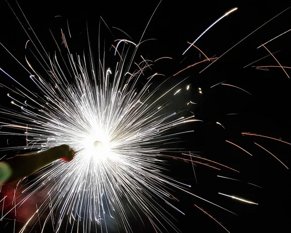 Mano charki, un fuoco d'artificio a mano che emette scintille circolari in sfondo nero — Foto Stock