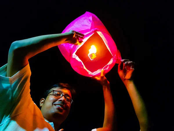 Un Indien relâchant une montgolfière en papier allumé dans le ciel lanterne festival — Photo