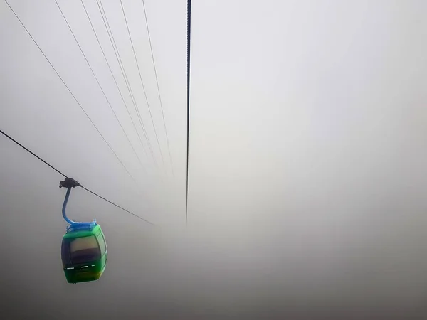 Un teleférico suspendido en un cable en un clima muy nebuloso con cero visibilidad — Foto de Stock