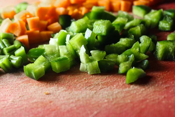 capsicum and carrot cut into small pieces,finely chopped vegetables on a chopping board
