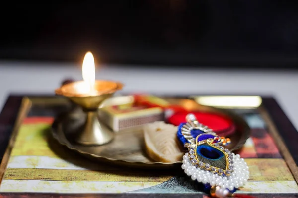 Une assiette thali décorée de rakhi douce lampe diya pour l'occasion de rakshabandhan salutation de frère et sœur — Photo