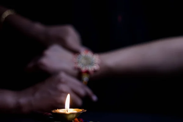 Mano de una dama atando rakhi en la mano de un chico durante el ritual hindú de rakshabandhan con enfoque selectivo —  Fotos de Stock