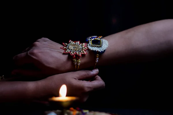 Hand of a lady tying rakhi in hand of a guy during the hindu ritual of rakshabandhan with selective focus — Stock Photo, Image
