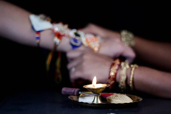 Mano de una dama atando rakhi en la mano de un chico durante el ritual hindú de rakshabandhan con enfoque selectivo —  Fotos de Stock