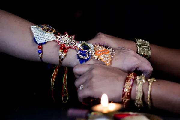 Hand of a lady tying rakhi in hand of a guy during the hindu ritual of rakshabandhan with selective focus — Stock Photo, Image