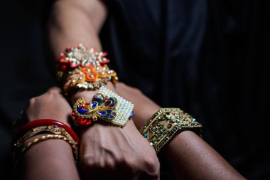 seçici odak ile rakshabandhan hindu ritüel sırasında bir adamın elinde rakhi bağlayan bir bayan el