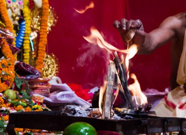 alev yakıt ekleyerek ateş ve yagna ritüel ile Hindu tanrı ibadet bir rahip eli