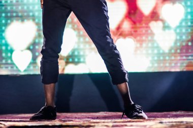 arka plan neon ışıkları ile hip hop dans duruş yapıyor sahnede bir dansçı ayakları