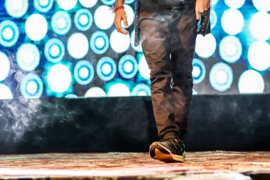 arka plan neon ışıkları ile hip hop dans duruş yapıyor sahnede bir dansçı ayakları