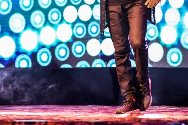 arka plan neon ışıkları ile hip hop dans duruş yapıyor sahnede bir dansçı ayakları