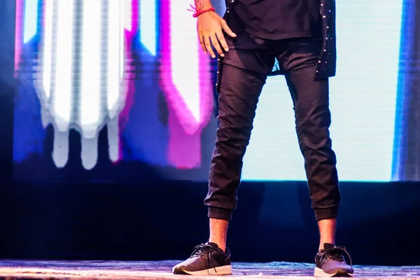 Ноги танцовщицы на сцене, танцующей хип-хоп в позе с неоновым фоном — стоковое фото