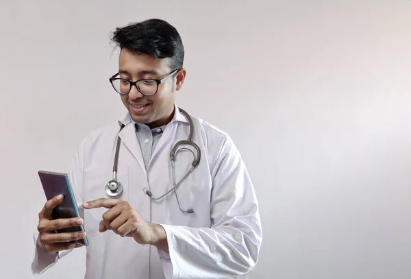 beyaz ceket ve stetoskop akıllı telefon dokunmadan erkek hint doktor