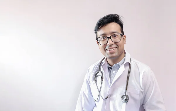 Чоловічий індійський лікар у білому пальто та стетоскоп з простором для тексту на білому тлі — стокове фото