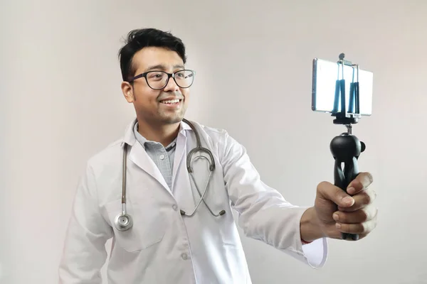 Mężczyzna indyjski lekarz w białym płaszczu i stetoskop klikając selfie — Zdjęcie stockowe