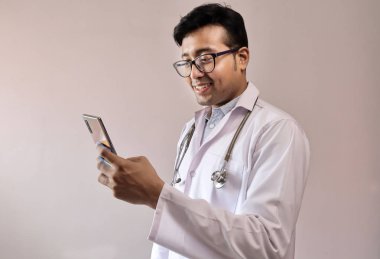 beyaz ceket ve stetoskop akıllı telefon dokunmadan erkek hint doktor