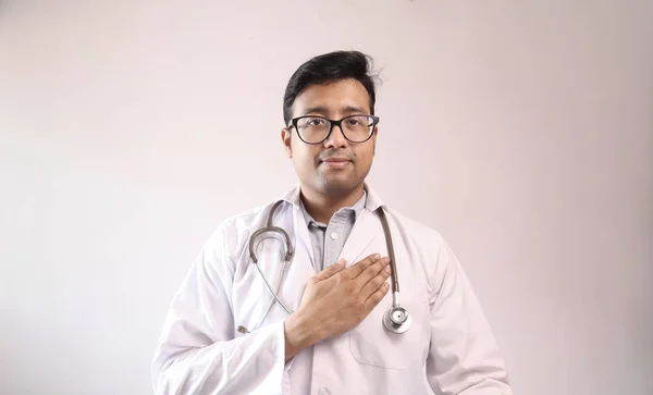 Индийский врач в белом халате и стетоскопе, присягающий на гиппократии — стоковое фото